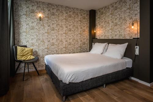 东弗利兰Loods Hotel Vlieland的一间卧室配有一张床和一把椅子