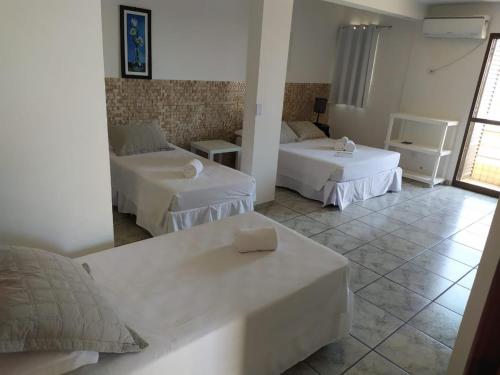 瓜拉图巴Hotel Nautico的酒店客房,设有两张床和一张沙发
