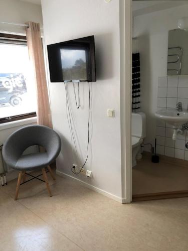 福勒松德Gotlands Idrottscenter Vandrarhem的浴室设有椅子,墙上设有电视