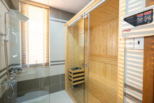 大叻La Fleur Premium Central Apartment Hotel的浴室里设有玻璃门淋浴