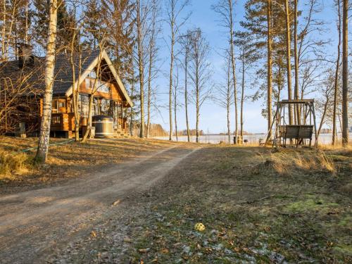 PuromäkiHoliday Home Huvilakoti 1 by Interhome的泥路旁树林中的小木屋
