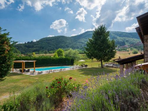 VitoioHoliday Home La Fenice by Interhome的花园的背景是游泳池和山脉