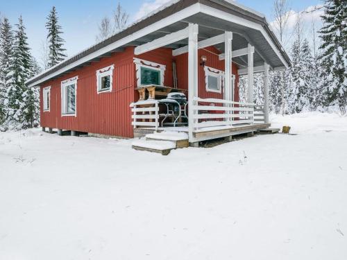 JuhanalaHoliday Home Mäntylä by Interhome的雪中红房子,有雪覆盖的树木