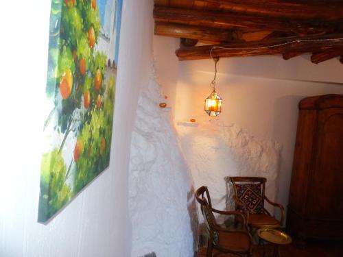 Mondújar德拉巴卡旅馆的墙上有画作的房间和椅子