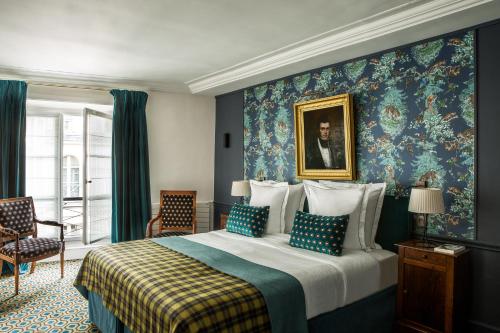 巴黎芒萨尔法兰西精神酒店的一间卧室配有一张特大号床和蓝色的墙壁