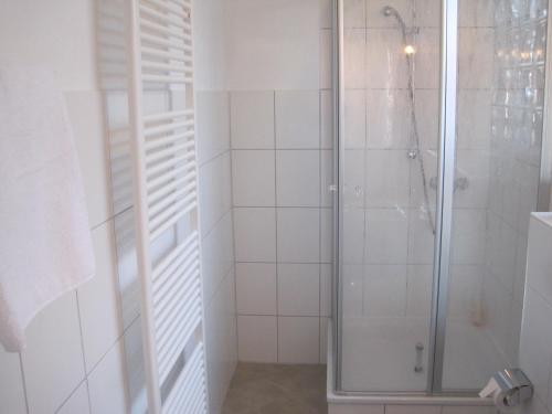 威廉港Central Wohnen的浴室铺有白色瓷砖,设有淋浴。