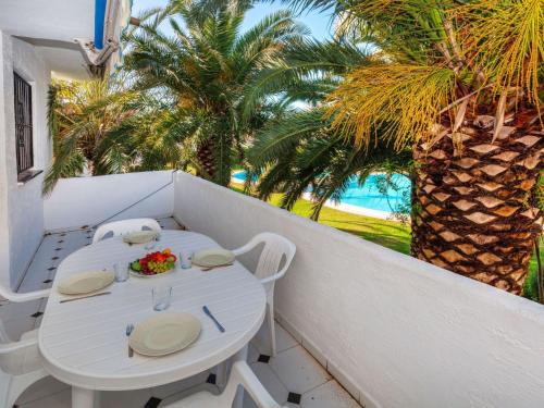 帕尔斯Apartment Ducado Golf CII by Interhome的棕榈树阳台的白色桌椅