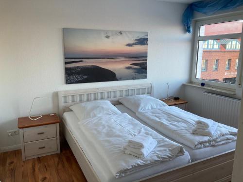 威克奥夫弗尔Hellinghaus FeWo 3 Strandläufer的卧室配有两张床,墙上挂着一幅画
