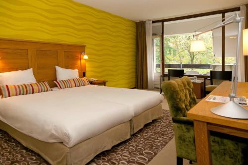 莱森弗莱彻酒店的酒店客房设有一张大床和一张书桌。