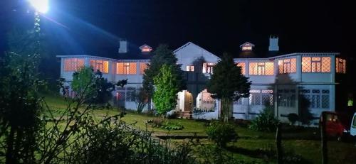 大吉岭Rani Kothi Heritage Residency的一座在晚上有灯的大建筑