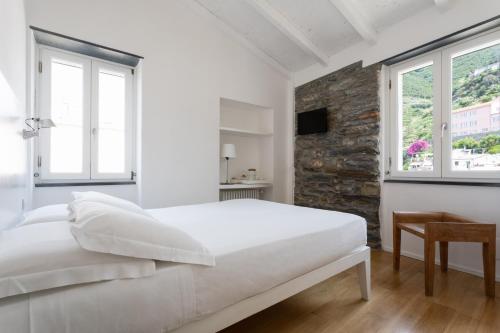 韦尔纳扎La Malà - camere di charme的白色卧室设有大床和窗户