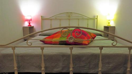 GasponiCasita GioJa的一张金属床,上面有五颜六色的枕头