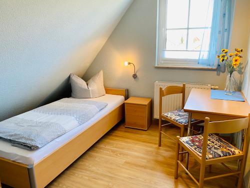 卡尔斯哈根Dünenresidenz Heideweg 7a的一间小卧室,配有一张床和一张书桌