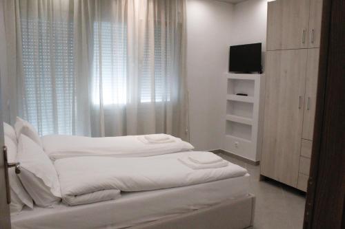 兹拉马Apartment Ori的一间白色卧室,配有床和电视