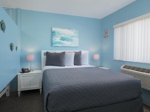 可可比奇南海滩汽车旅馆 - 可可海滩的蓝色的卧室设有一张大床和一个窗户