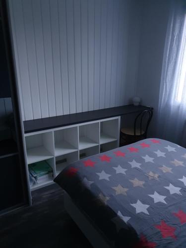 GuipavasChambre d hote avec sa SDB privative的一间卧室配有一张红色白色和蓝色棉被的床
