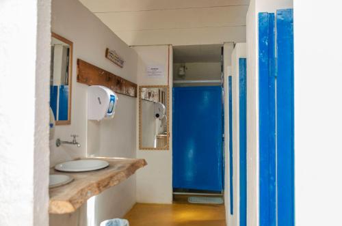 伊利亚贝拉Clan.Destino Hostel的一间带两个水槽和蓝色门的浴室