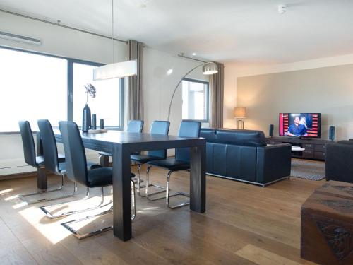 斯海弗宁恩Luxury apartment in the harbor of Scheveningen的客厅设有餐桌和椅子