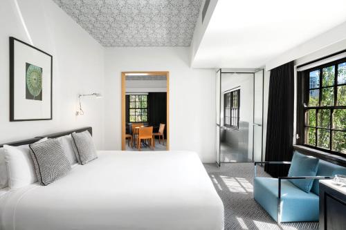 堪培拉辣椒画廊酒店的卧室配有白色的床和窗户。