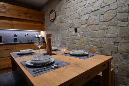 泽勒兹纳·鲁达Chalet Apartments Maštal的厨房里一张桌子,上面有玻璃杯和盘子