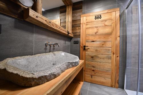 泽勒兹纳·鲁达Chalet Apartments Maštal的一间带大型石质浴缸和木门的浴室