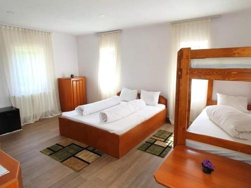 斯塔纳德瓦勒Vila IZVORUL MINUNILOR的卧室配有2张双层床和白色床单