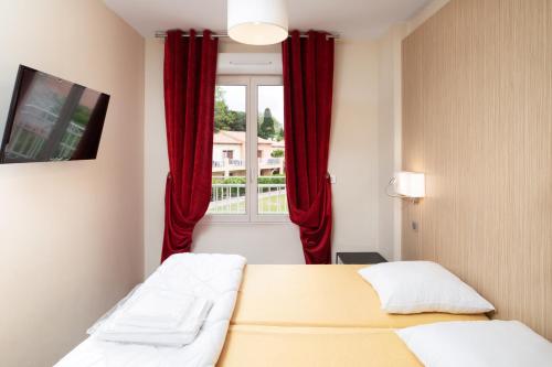 格里莫SOWELL RESIDENCES Les Perles de Saint Tropez的一间卧室设有两张床,窗户配有红色窗帘