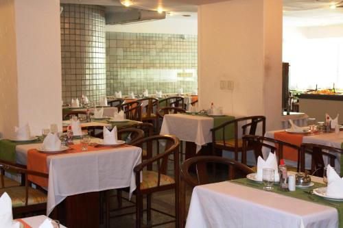 累西腓Aram Beach Boa Viagem的用餐室配有桌椅和白色桌布