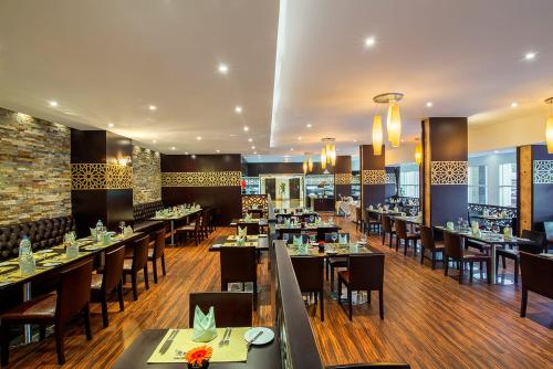 阿布扎比Metropolitan Al Mafraq Hotel的餐厅内带桌椅的用餐室