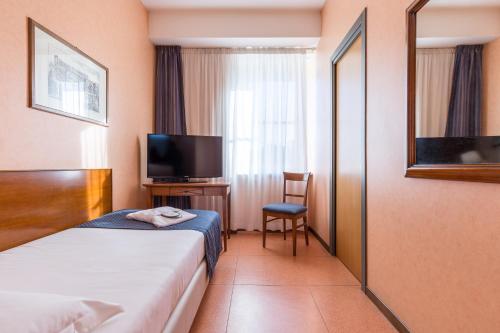 罗马EUR松树公园别墅酒店的酒店客房,配有床和电视