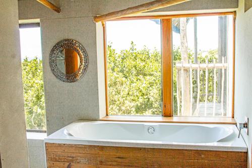托弗海滩Tree House Villa的带浴缸的浴室和窗户