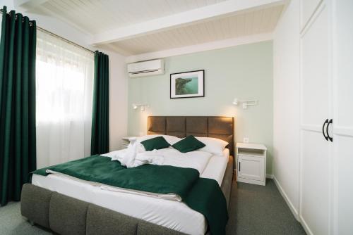 巴拉通尤洛克黄玉公寓酒店的一间卧室配有一张带绿毯的大床