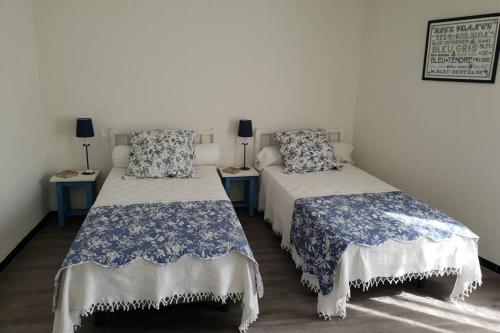 埃尔讷Charmante maison de ville F3 avec garage et cour的配有两张蓝色和白色床单的床铺