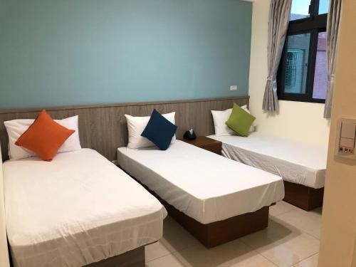 金宁乡熊宝贝民宿的客房设有三张床和色彩缤纷的枕头。