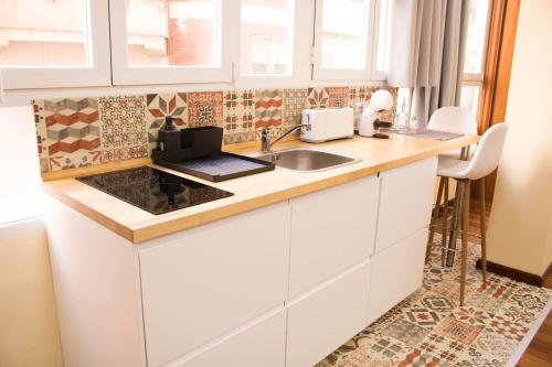 阿尔么丽亚LOFT CENTRO ALMERIA的厨房配有白色橱柜和水槽