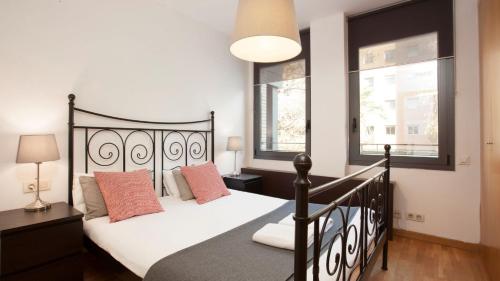 巴塞罗那RAMBLA BEACH Barcelonastuff Apartments的一间卧室设有一张黑色的床和两个窗户。