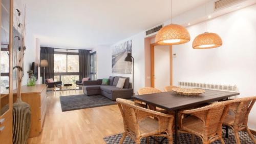 巴塞罗那RAMBLA BEACH Barcelonastuff Apartments的用餐室以及带桌椅的起居室。