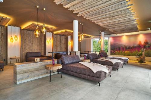 博登迈斯Camping Resort Bodenmais的客厅配有沙发、桌子和绘画作品