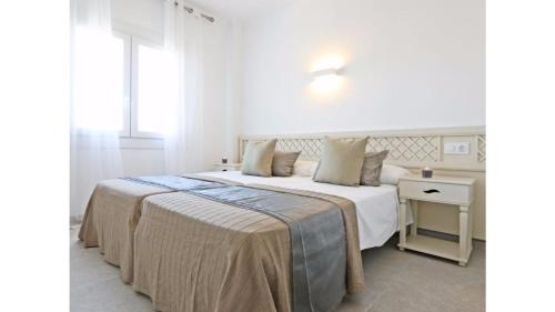 松塞尔韦拉Apartamentos Sema的白色卧室配有一张大床和一张桌子