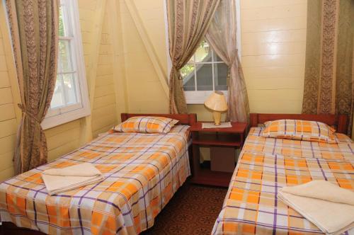 圣安德烈斯Coconut Paradise Lodge的客房设有两张床、一张桌子和一扇窗户。