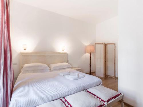 卡瓦伊翁韦罗内塞Apartment Tenuta Naiano Raffaello的白色卧室配有两张床和一盏灯