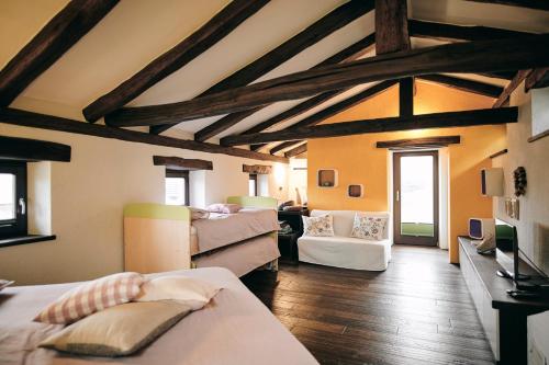 塞扎纳Tmbin's barn - nature, horses, family的一间设有床铺的客房和一间带木制天花板的客厅
