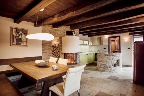 塞扎纳Tmbin's barn - nature, horses, family的一间带木桌和壁炉的用餐室