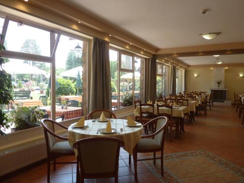 鲍洛通凯赖斯图尔撒奈特酒店的用餐室配有桌椅和大窗户
