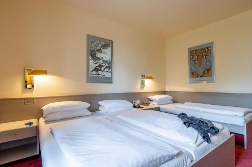 巴登-巴登Hotel Baden-Baden的配有2张单人床的客房,配有2盏灯