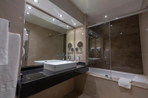 迈尔提勒奥梅亚套房酒店的浴室配有盥洗盆和带镜子的淋浴