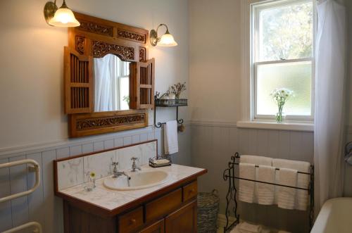 格雷敦萨多勒里乡村别墅的一间带水槽和镜子的浴室以及窗户。