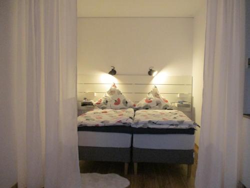罗伊特林根Apartment am Apfelbaum的一间小卧室,配有白色窗帘