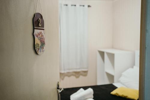 乌鲁比西Pousada Recanto da Serra - Unidade Campestre的卧室的门,卧室配有一张床,墙上挂着一个钟