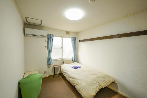 芝山町成田スカイパークイン芝山的小房间设有床和窗户